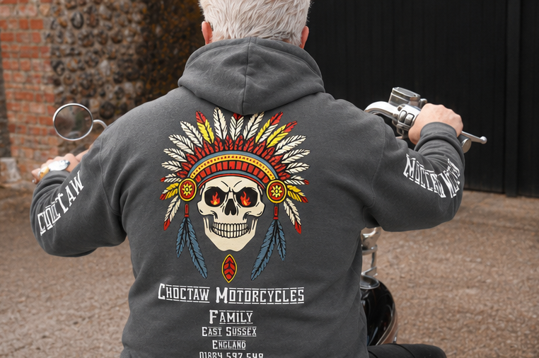 Person wearing a gray hoodie with a Choctaw Motorcycles design, sitting on a motorcycle.